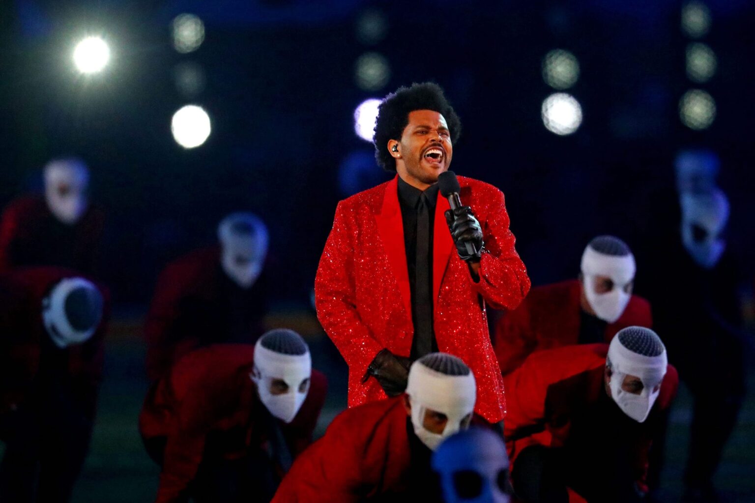 "Blinding Lights" singer The Weeknd has had a steady stay in the headlines over the past year. Why did his dancers wear face bandages?
