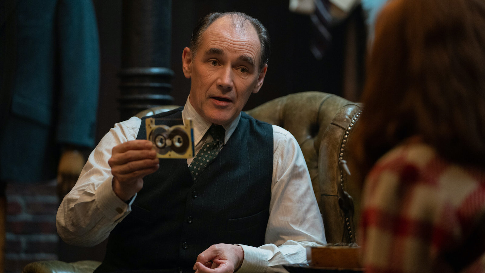 Mark Rylance as a tailor in league with the mob, he's holding up a tape