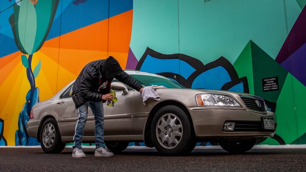 Alt-text: A man polishing his vintage car